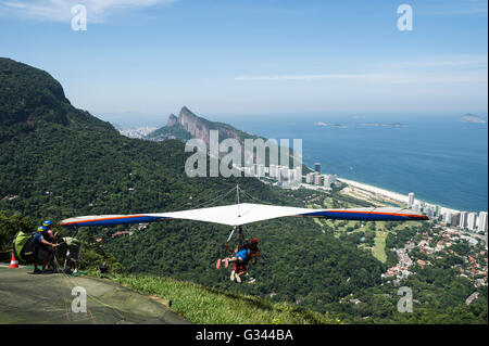 RIO DE JANEIRO - 22. März 2016: Eine Hängegleiter Lehrer startet mit einem Passagier von Pedra Bonita, São Conrado. Stockfoto