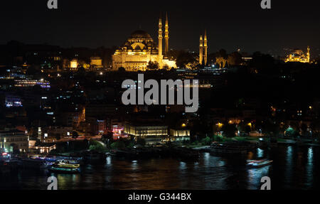 Skyline Istanbuls vom Galata-Brücke bei Nacht mit Süleymaniye Moschee und Fisch-Boot-Restaurants in Eminönü Stockfoto