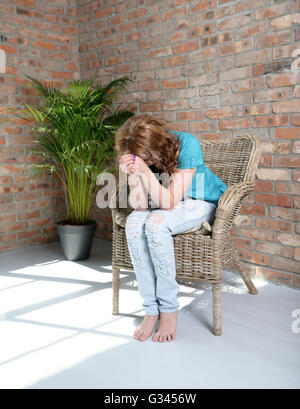 Frau sitzt auf dem Stuhl in depression Stockfoto