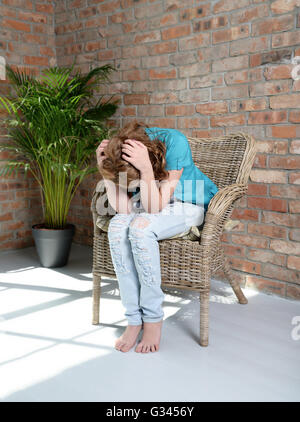 Frau sitzt auf dem Stuhl in depression Stockfoto