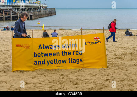 Ein Schild an Bournemouth Beach Warnung Menschen am Strand von Bournemouth, zwischen den roten und gelben Flaggen zu schwimmen. Stockfoto