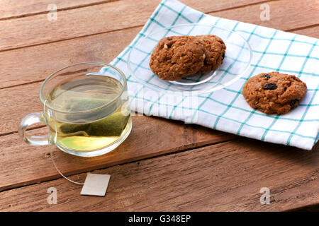 Pokal Glas grüner Tee und Cookies auf hölzernen Hintergrund. Licht in der Natur. Stockfoto