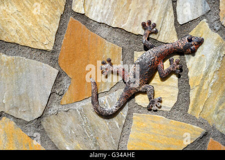 Gecko aus Metall auf einer Steinmauer gemacht Stockfoto