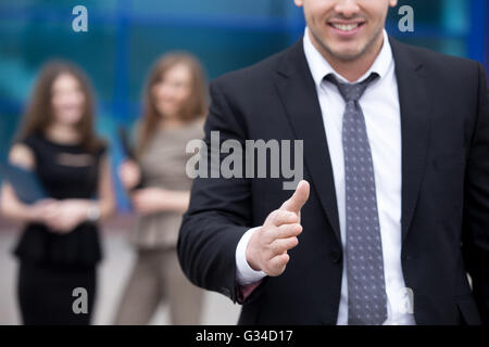 Zuversichtlich junger Geschäftsmann bietet Hand zur Begrüßung oder Vereinbarung Handshake im Freien. Erfolgreiches Konzept. Geschäftsleute Stockfoto