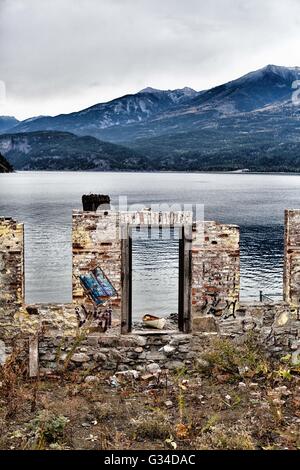 Verlassen; über die Notwendigkeit der Instandsetzung verwahrloster alter Gebäude in der Nähe der oberen Kootney Kaslo Lake in British Columbia, mit Graffiti. Stockfoto