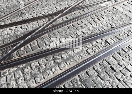 Schnittpunkt der Straßenbahnschienen auf grauem Stein Pflaster Stockfoto
