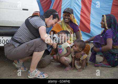 Lady Fotograf zeigt die Bilder an die Kinder genommen, Maha Kumbh Mela, Ujjain, Madhya Pradesh, Indien Stockfoto