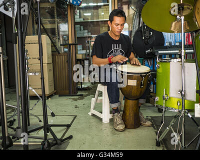 Bangkok, Bangkok, Thailand. 7. Juni 2016. Ein Trommel-Verkäufer spielt Bongo Stil Trommel in seinem Geschäft für Musikinstrumente in Verng Nakorn Kasem, auch bekannt als die Diebe Markt. Verng Nakorn Kasem war einer der berühmtesten Einkaufsviertel Bangkoks. Es befindet sich am nördlichen Rand von Bangkoks Chinatown, es wuchs in Bangkoks Stadtteil für Kauf und Verkauf von Musikinstrumenten. Die Familie, die das Land im Besitz vor kurzem verkauft, und die neuen Besitzer wollen das berühmte Gebiet zu sanieren und schalten ihn in ein Einkaufszentrum. Die neuen Besitzer haben begonnen, bestehende Mietvertrag Inhaber vertreiben und viele Geschäfte geschlossen haben. © Stockfoto