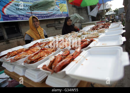 Batam, Indonesien. 8. Juni 2016. Gegrillter Fischhändler servieren Käufer in traditionellen Märkten Kampung Tua Tanjung Uma. Verschiedene Arten von frisch gegrillten Fisch, Tintenfisch und Krabben von den Fischern können roh oder in den Kraftstoff in das Optionen-Menü-Iftar im Ramadan erworben werden. Ramadan Pasar Tanjung Uma ist der Markt am häufigsten besuchten Batam Bewohner während des Fastenmonats. Dieser Markt ist der älteste Ramadan-Basar in der Stadt von Batam. © Teguh Prihatna/Pacific Press/Alamy Live-Nachrichten Stockfoto