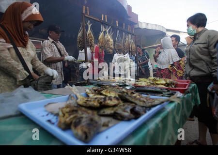 Batam, Indonesien. 8. Juni 2016. Gegrillter Fischhändler servieren Käufer in traditionellen Märkten Kampung Tua Tanjung Uma. Verschiedene Arten von frisch gegrillten Fisch, Tintenfisch und Krabben von den Fischern können roh oder in den Kraftstoff in das Optionen-Menü-Iftar im Ramadan erworben werden. Ramadan Pasar Tanjung Uma ist der Markt am häufigsten besuchten Batam Bewohner während des Fastenmonats. Dieser Markt ist der älteste Ramadan-Basar in der Stadt von Batam. © Teguh Prihatna/Pacific Press/Alamy Live-Nachrichten Stockfoto