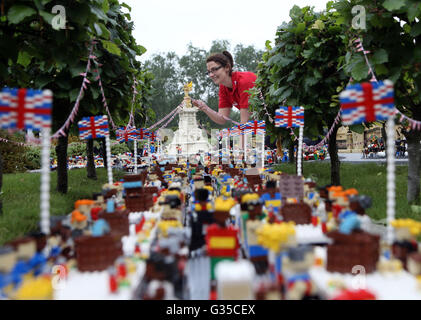 LEGOLAND Windsor Resort Modellbauer Kat James verleiht den letzten Schliff ein Miniatur-Straßenfest außerhalb eines Modells des Buckingham Palace im Miniland vor der Patron Mittagessen auf der Mall in London anlässlich der Königin offizielle 90. Geburtstag am 12. Juni. Stockfoto