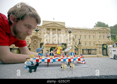 LEGOLAND Windsor Resort Modellbauer Guy Groom verleiht den letzten Schliff ein Miniatur-Straßenfest außerhalb eines Modells des Buckingham Palace im Miniland vor der Patron Mittagessen auf der Mall anlässlich der Königin offizielle 90. Geburtstag am 12. Juni. Stockfoto