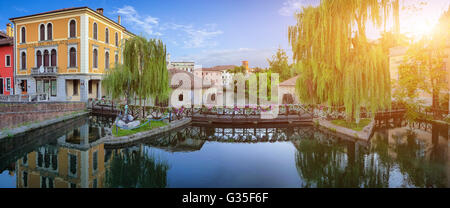 Idllyic Blick auf berühmte Mühlen am Fluss Lemene in der Altstadt von Portogruaro im goldenen Abendlicht, Italien Stockfoto