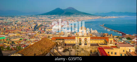 Malerischen Postkarten-Blick auf die Stadt von Napoli (Neapel) mit berühmten Vesuv im Hintergrund im goldenen Abendlicht Stockfoto