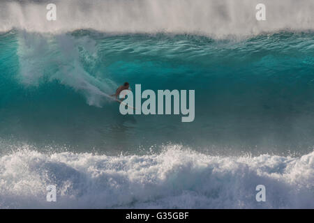 Ein Surfer bei Banzai Pipeline während einer großen Wellengang auf der Nordküste von Oahu. Stockfoto