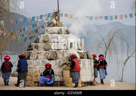 CHINA Yunnan, Lugu-See, ethnische Minderheit Mosuo, die buddhistischen und Frauen haben eine Matriarchin / CHINA Provinz Yunnan, Ethnische Minderheit Mosuo am Lugu-See, Mosuo Sind Buddhisten Und Mosuo Frauen sterben Ueben Ein Matriarchat aus, Frauen Mit Gebetsmuehlen Umrunden Einen Scgrein am Lugu-See Stockfoto