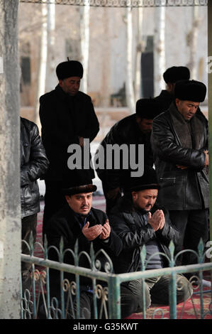 CHINA Provinz Xinjiang, Stadt Kashgar, wo uigurischen Volkes leben, Heytgar oder Idkah Moschee, muslimische Männer an Gebet, uigurische Männer einen Hut tragen, Id kah-Moschee ist die grösste Moschee in China und kann bis zu 20.000 Verehrer aufnehmen Stockfoto