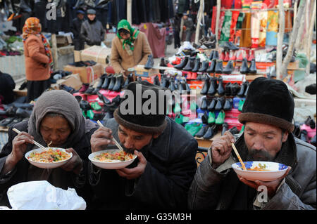 CHINA, Provinz Xinjiang, Markttag in der uigurischen Dorf Jin Erek in der Nähe der Stadt Kashgar, wo der Uiguren leben Leute, alte Menschen essen Nudelsuppe mit Stäbchen Stockfoto
