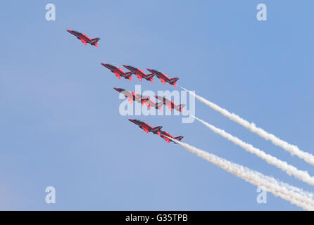 Die Royal Air Force Red Arrows Kunstflugstaffel fliegen in Formation vor blauem Himmel, Duxford Airshow, UK; Führung-Konzept Stockfoto