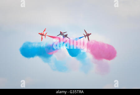 Rote Pfeile RAF aerobatic Teamleistung, tun eine Crossover mit bunten Rauch, Duxford Airshow, Cambridgeshire UK Stockfoto
