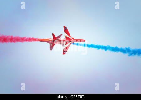 Rote Pfeile RAF aerobatic Team Durchführung eine Crossover mit farbigen Rauch; Duxford Airshow Duxford Cambridgeshire UK Stockfoto