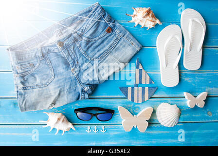 Sonnige Sommerkleidung und Dekoration auf hölzernen Hintergrund Stockfoto