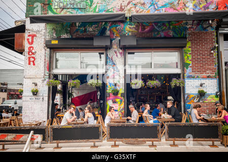 Al Fresco Dining in bushwick, Brooklyn in New York während der jährlichen Bushwick kollektive Block Party am Samstag, 4. Juni 2016. Musik und Party brachte einige, aber die eigentliche Attraktion war das neue Graffiti Wandmalereien von 'Künstler', die die Wände der Gebäude, die die Kollektive verwendet dekorieren. (© Richard b. Levine) Stockfoto