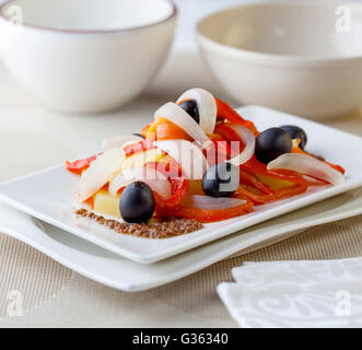 Ein Salat mit Kartoffeln, Sardellen, Paprika, Zwiebeln und Oliven Stockfoto