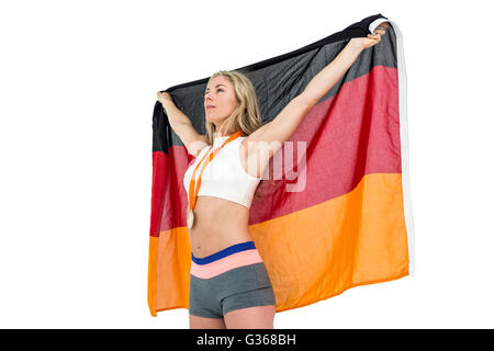 Athlet posiert mit deutscher Flagge nach Sieg Stockfoto