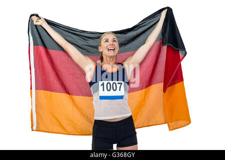 Athlet posiert mit deutscher Flagge nach Sieg Stockfoto