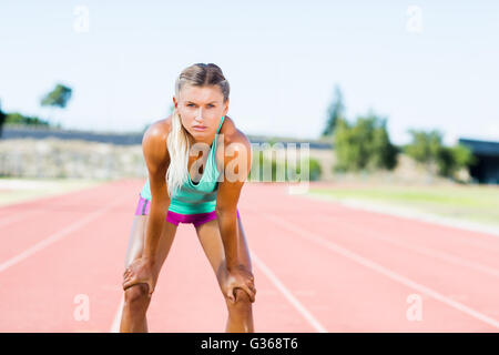 Müde Sportlerin stehend auf der Laufstrecke Stockfoto