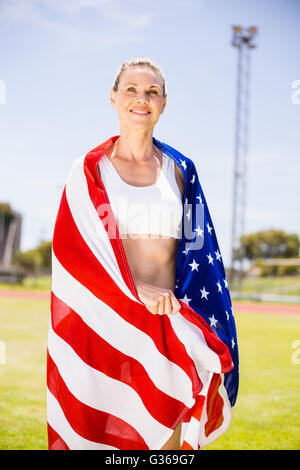 Glückliche Athletin in der amerikanischen Flagge gewickelt Stockfoto