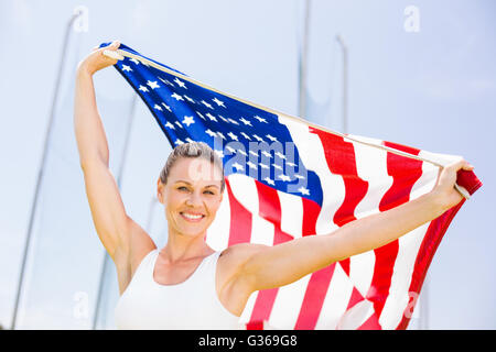 Glücklich Sportlerin, die amerikanische Flagge hochhalten Stockfoto