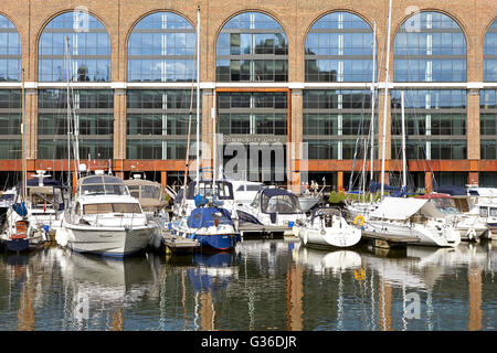 Line-up von Yachten vor dem Gebäude Eingang. Rohstoff-Kai, London, Vereinigtes Königreich. Architekt: BuckleyGrayYeoman, 2014. Stockfoto