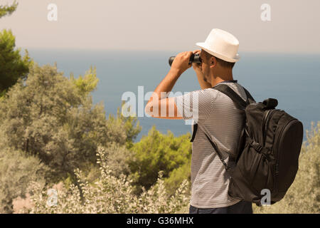 Touristen auf der Suche durch ein Fernglas auf einem Hügel nahe dem Meer Stockfoto