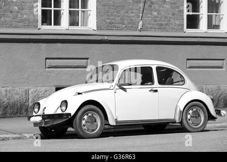 Helsinki, Finnland - 7. Mai 2016: Alten gelben VW Käfer an einem Straßenrand, schwarzen und weißen geparkt ist Stockfoto