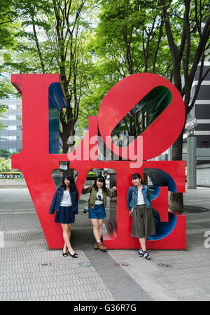 Drei japanische Mädchen mit Liebe Skulptur, Shinjuku, Tokio, Japan Stockfoto