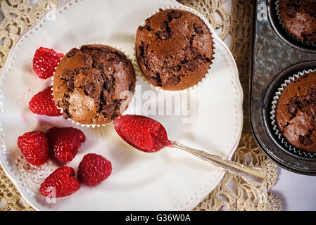 Schokoladen-Muffins mit roten saftigen Himbeeren Stockfoto