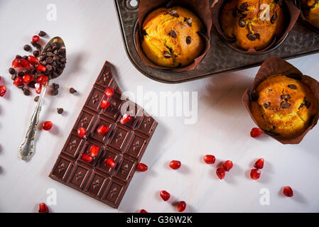 Schokoladen-Muffins mit einer Tafel Schokolade und rote Granatapfel Früchte. Stockfoto