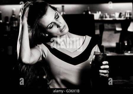 Eine junge Dame trinkt auf ihrer Party und posiert für ein Foto in einer Bar irgendwo in England Großbritannien Stockfoto