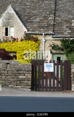 Privater Garten Zeichen in Englisch und Chinesisch auf dem Tor von einem Ferienhaus in Bibury. Cotswolds, Gloucestershire, England Stockfoto