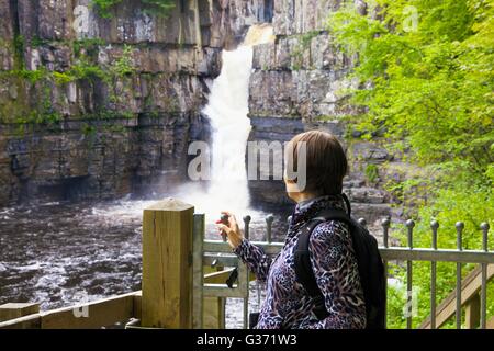 Frau betrachten hohe Kraft Wasserfall, River Tees, Wald-in-Teesdale, Durham Dales, Middleton-in-Teesdale, County Durham, Großbritannien. Stockfoto