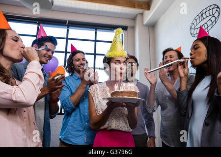 Glückliche Mitarbeiter bläst Kerzen zum Geburtstag Stockfoto