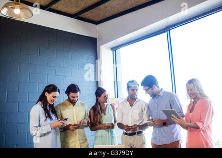 Gruppe von Mitarbeitern, die mit Laptops und smartphones Stockfoto