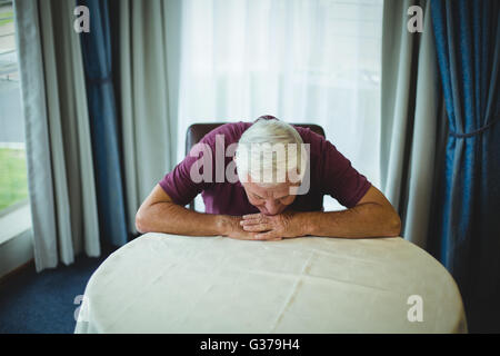 Besorgt senior Mann sitzt im Wohnzimmer Stockfoto