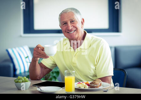 Senior woman Tee mit Frühstück Stockfoto