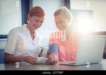 Krankenschwester Blutdruck senior Frau überprüfen Stockfoto