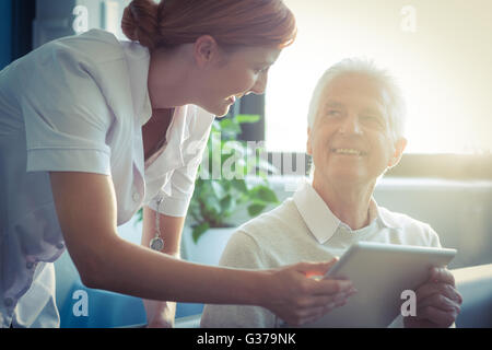 Krankenschwester Krankenbericht senior woman auf digitale Tablet zeigen Stockfoto