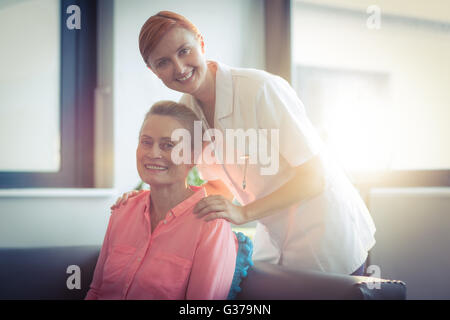 Porträt von glücklich Krankenschwester und Patient im Wohnzimmer Stockfoto