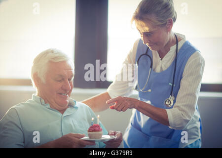 Senior weiblichen Arzt feiert Senior mans Geburtstag im Krankenhaus Stockfoto